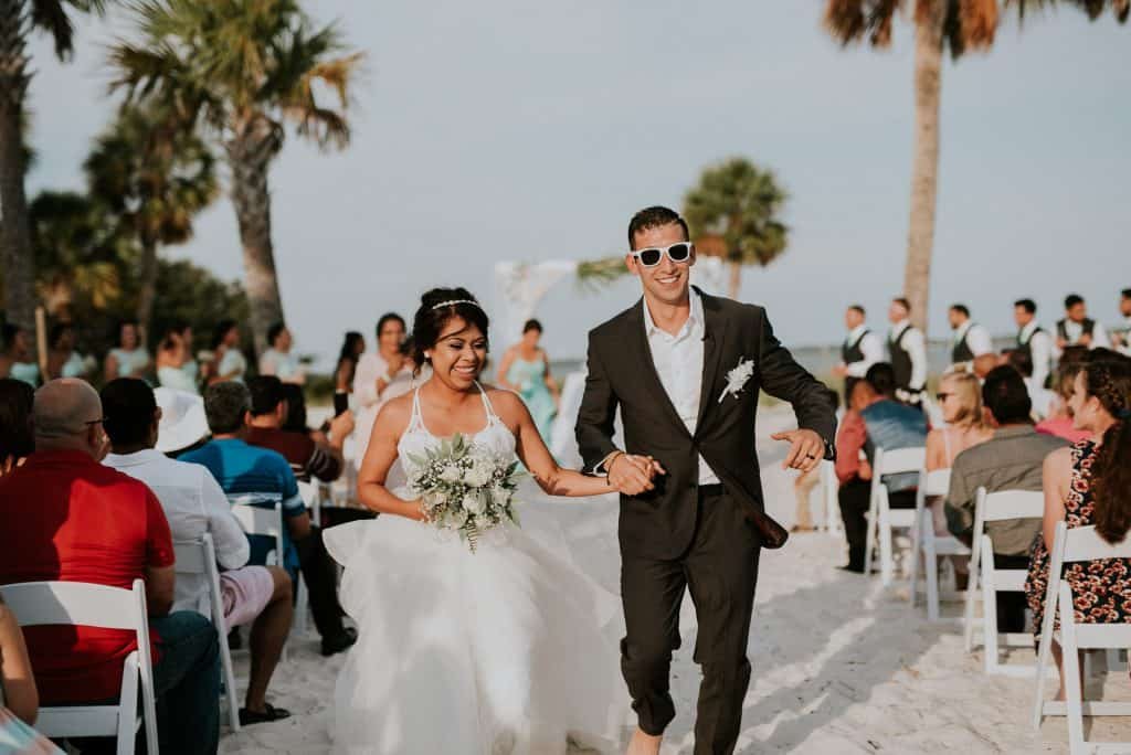 Happy bride and groom ceremony exit at the beach