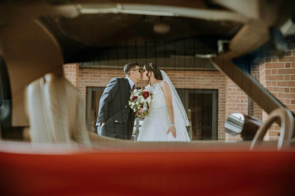 Bride and groom kissing in front of church