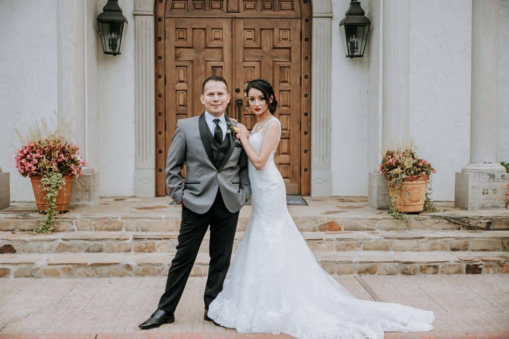 Wedding photography of bride and groom posing in front of the Chapel on the Creeks Rogers Arkansas