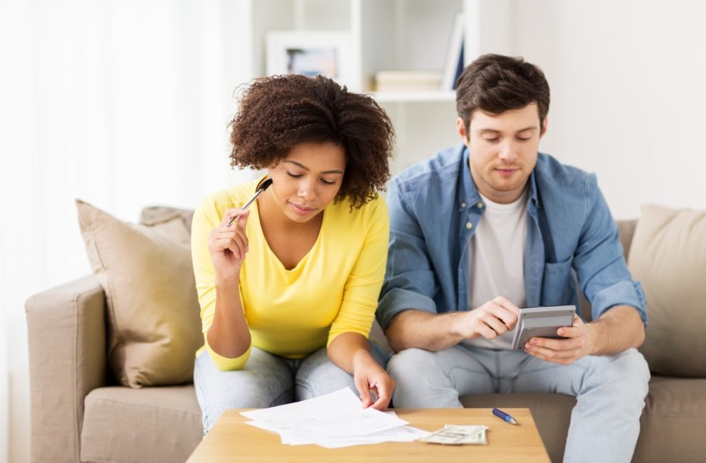 couple with papers and calculator at home