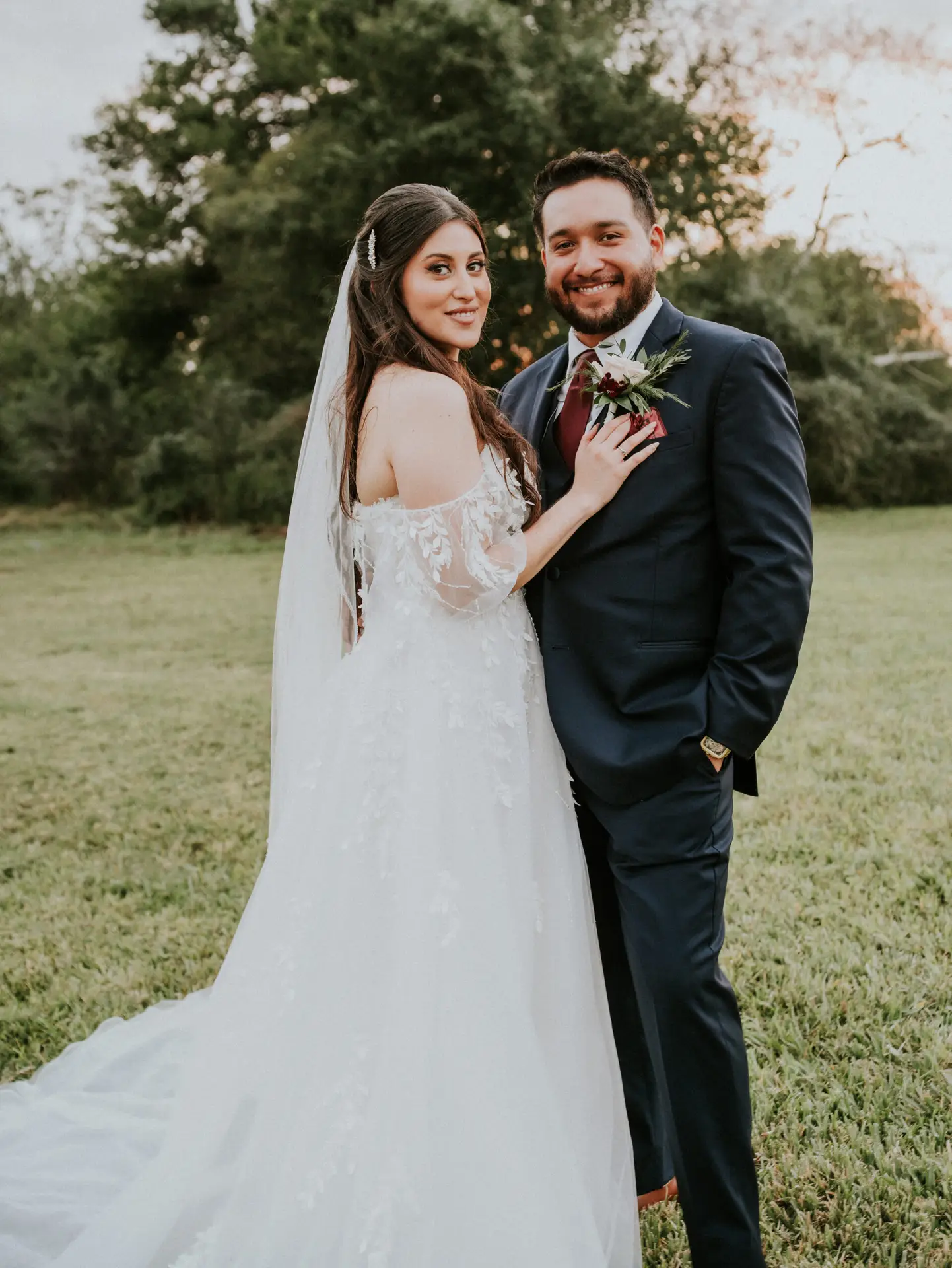 Bride and groom posing for their outdoor portrait session in the yard at Rancho La Pergola, San Benito, TX, after their ceremony.