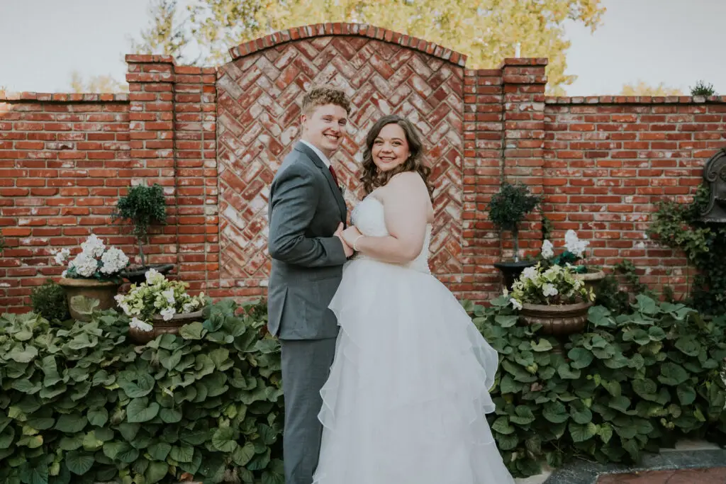 Couple in front of the brick garden wall at Mildred B. Cooper Memorial Chapel, Bella Vista, Arkansas
