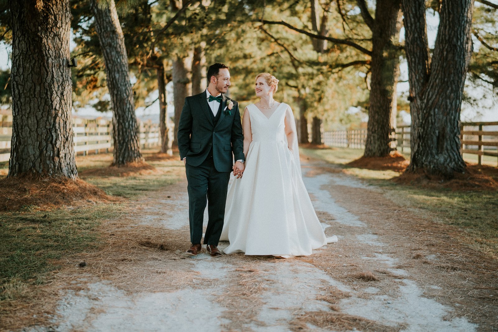 Home 19 Bride and groom walking a tree lined path at their Arkansas wedding