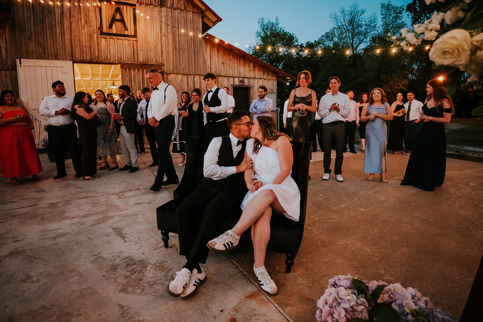 Holland Barn Wedding Videographer & Photographer 21 Guests dancing on the patio at dusk outside the barn at Holland Barn in Highfill, Arkansas