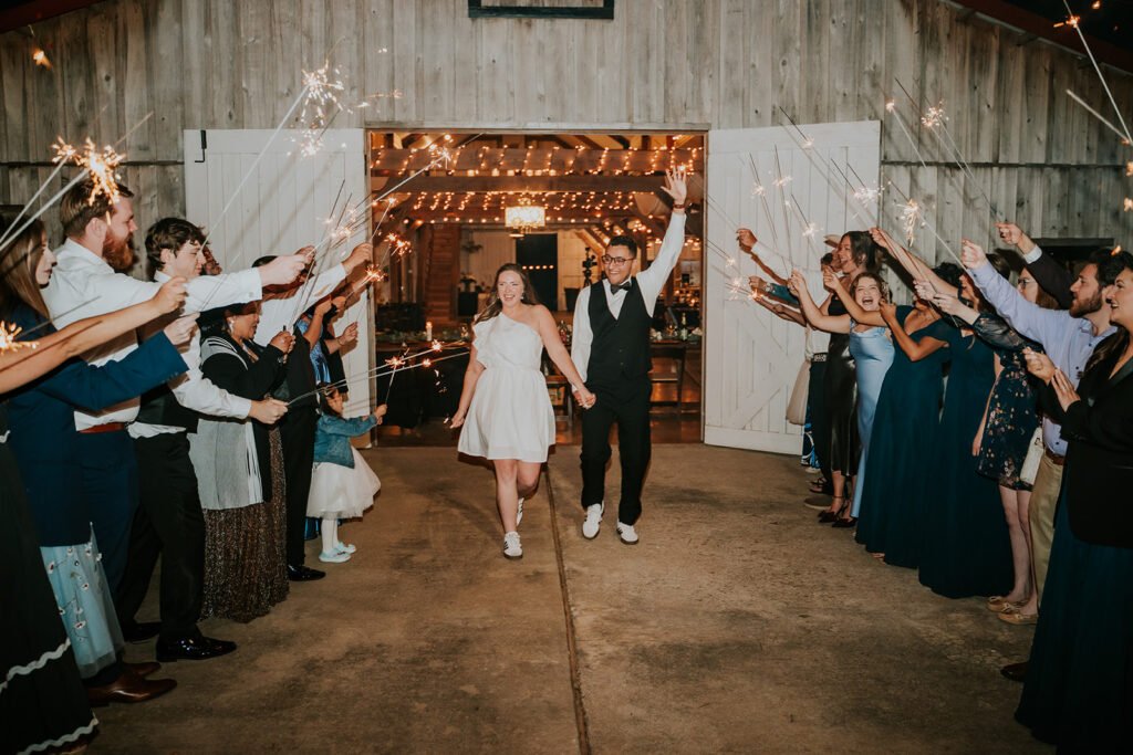 Sparkler exit through the barn doors at the end of a Holland Barn wedding in Highfill, Arkansas