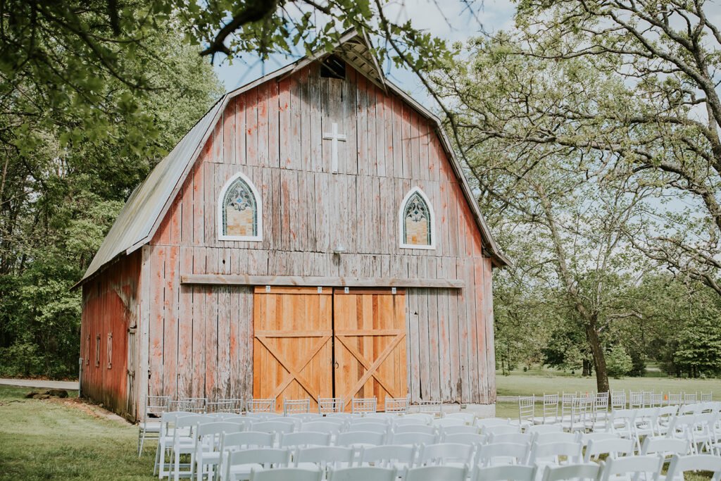 Amy's Chapel at Holland Barn set with white chairs for an outdoor wedding ceremony in Highfill, Arkansas