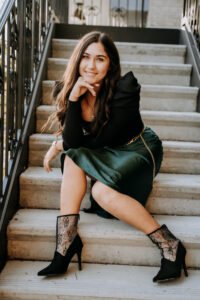 Senior girl posing on stone stairs with an iron railing on Dickson Street in Fayetteville, Arkansas
