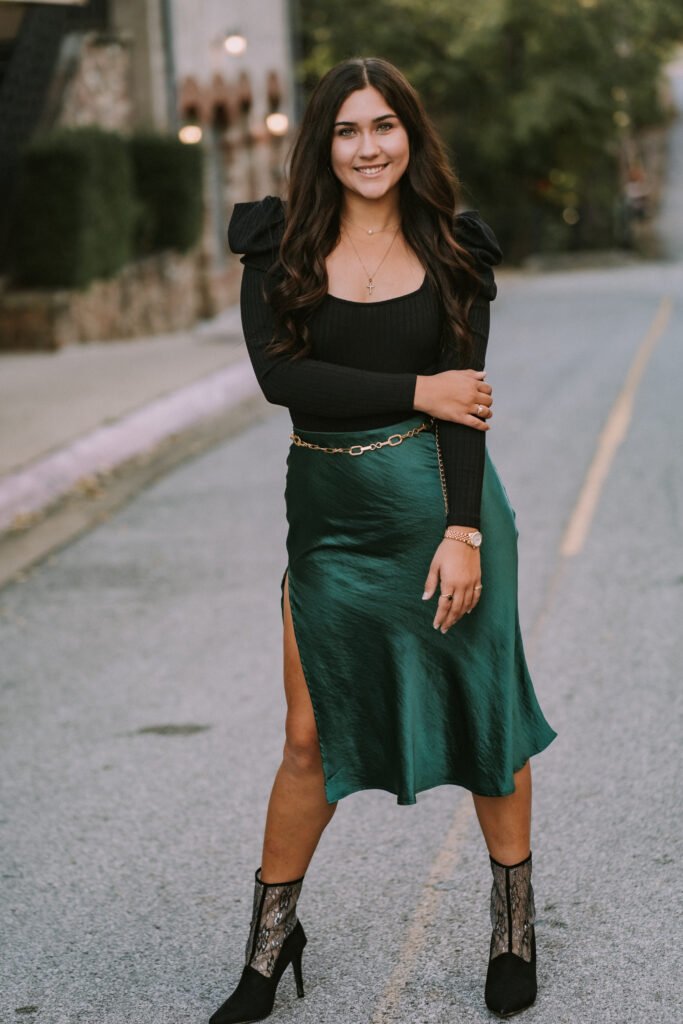 Senior in a green satin skirt on Dickson Street in Fayetteville