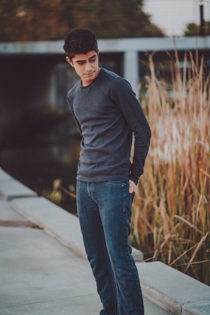 Senior guy in a dark sweater standing by the water