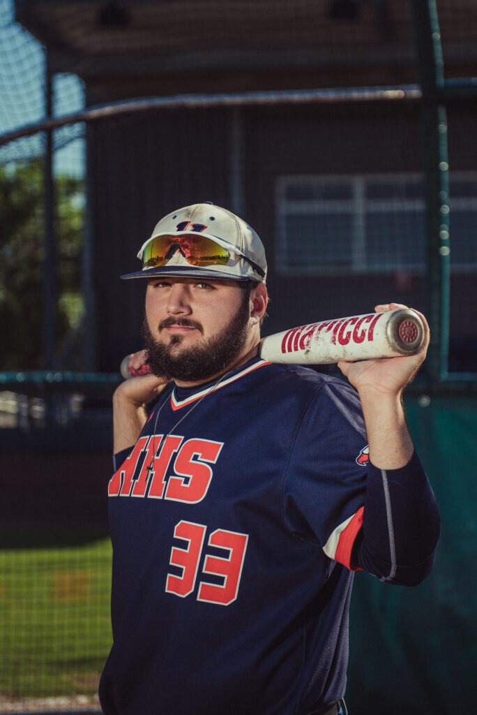 Senior baseball player holding a bat on his shoulder in his jersey
