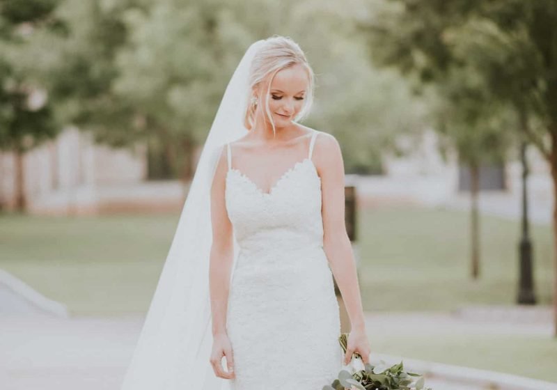 Bride in a veil and lace gown holding her bouquet during a bridal session