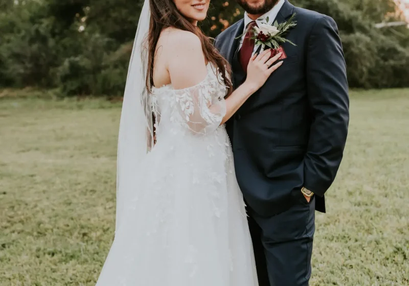 Bride and groom posing for their outdoor portrait session in the yard at Rancho La Pergola, San Benito, TX, after their ceremony.